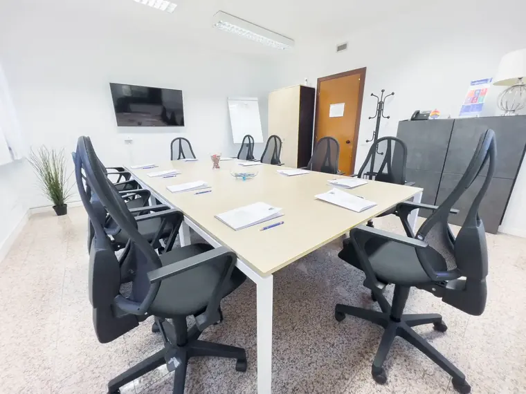 Sala riunioni con tavolo per dodici persone e monitor a parete — San Pietro
