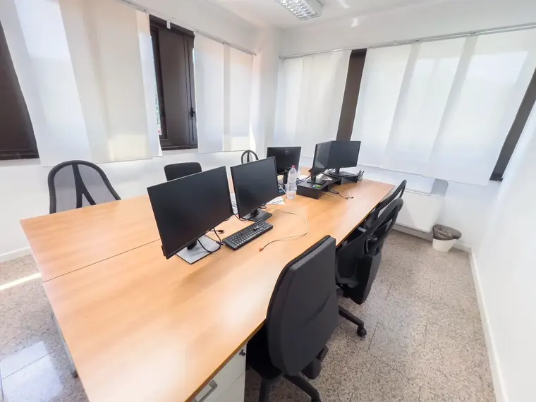 Open space con tavolo di lavoro in legno e postazioni — San Pietro